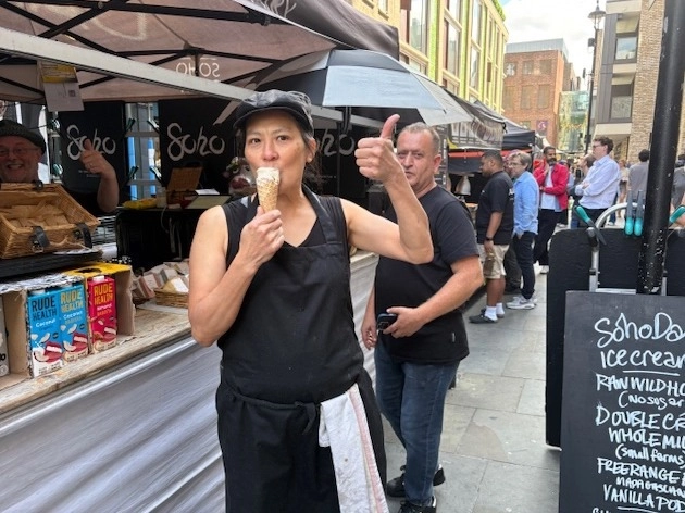 An image showing a woman at the Soho Dairy stall eating a Soho Dairy ice cream and giving a thumbs up