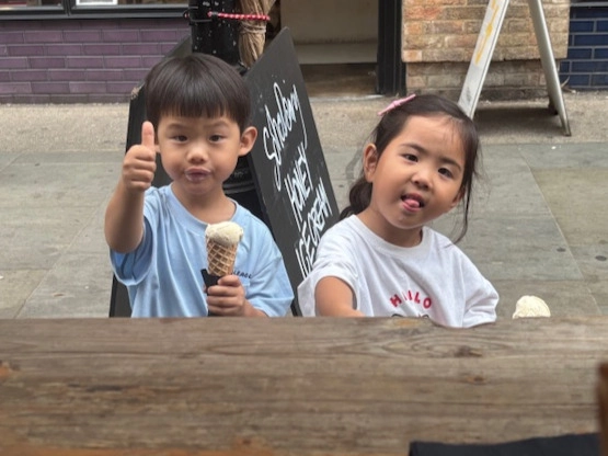 An image showing two children at the Soho Dairy stall eating a Soho Dairy ice cream and one of them giving a thumbs up